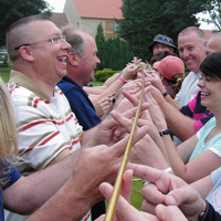 team having great fun with the Helium Stick team building activity